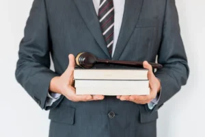 Takım elbiseli avukat, elinde hukuk kitapları ve yargı tokmağı ile – profesyonel hukuk danışmanlığı ve dava süreci.